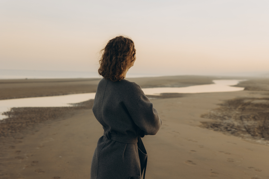 siento un vacío emocional constante mujer sola mirando al horizonte